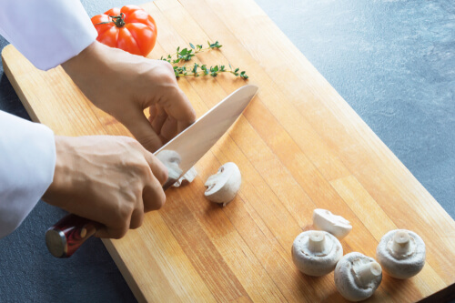 שפית משתמשת בסכין שף לחיתוך ירקות